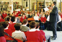 Gervase reading one of his poems to a group of high school children in the school library